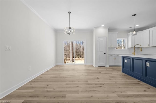 unfurnished dining area featuring baseboards, light wood finished floors, recessed lighting, ornamental molding, and a notable chandelier