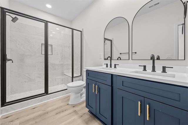 bathroom featuring toilet, wood finished floors, visible vents, and a sink