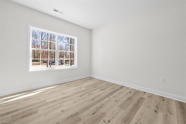 spare room with visible vents, baseboards, and light wood-style floors