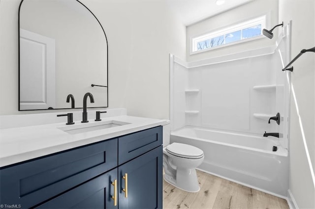 full bath featuring toilet, vanity, shower / bathtub combination, and wood finished floors