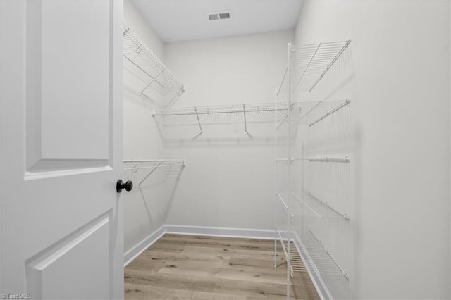 spacious closet featuring visible vents and wood finished floors