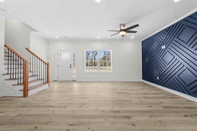 foyer entrance featuring baseboards, light wood finished floors, recessed lighting, stairs, and an accent wall