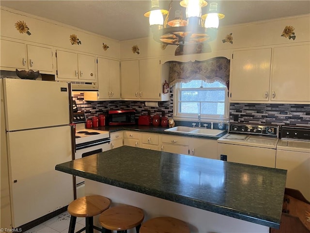 kitchen with white cabinets, washing machine and clothes dryer, sink, electric stove, and refrigerator