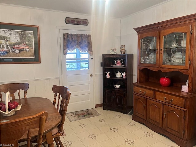 dining room featuring light tile patterned floors and crown molding