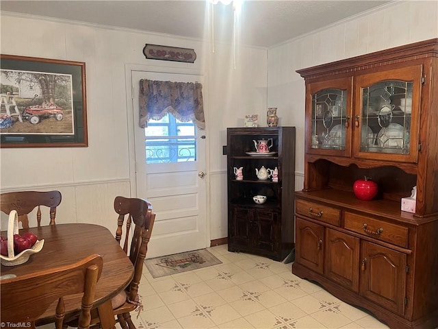 dining space featuring light tile patterned floors and ornamental molding