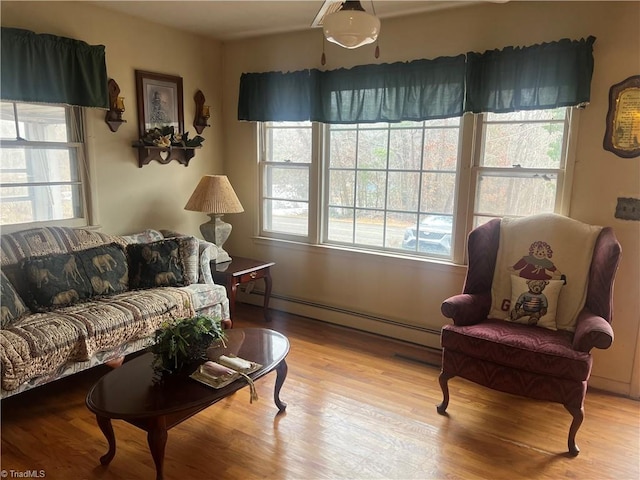 living room with light wood-type flooring and a baseboard heating unit