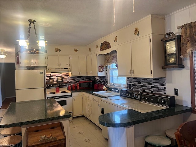 kitchen with kitchen peninsula, fridge, sink, and white range with electric stovetop