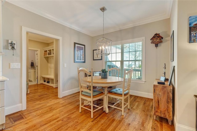 dining room featuring crown molding, a chandelier, and light wood-type flooring