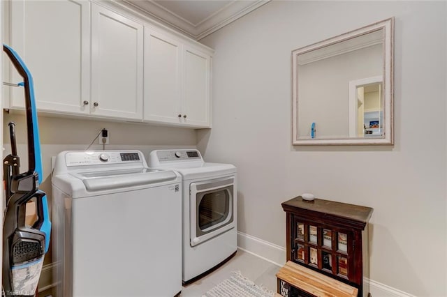 laundry room featuring cabinets, ornamental molding, and washer and dryer