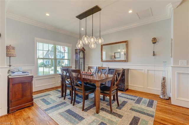 dining area featuring ornamental molding and light hardwood / wood-style flooring