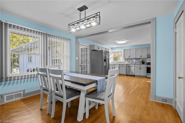 dining room featuring sink and light hardwood / wood-style floors