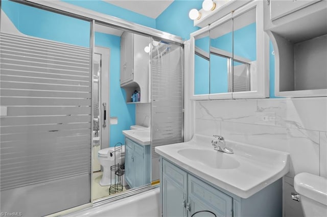 full bathroom with enclosed tub / shower combo, vanity, backsplash, and toilet