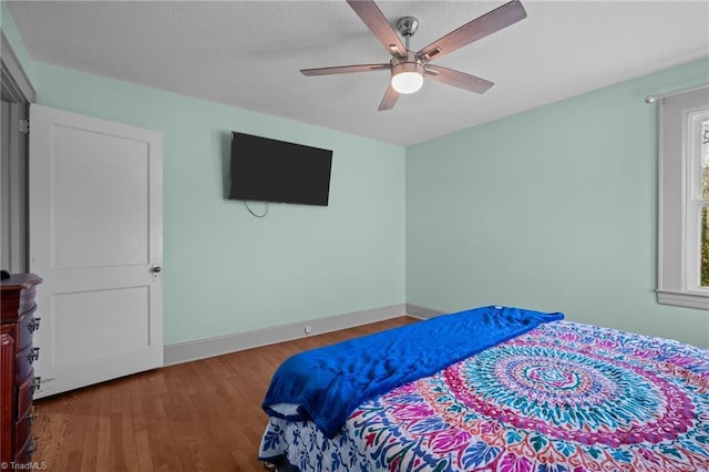 bedroom with hardwood / wood-style floors, a textured ceiling, and ceiling fan