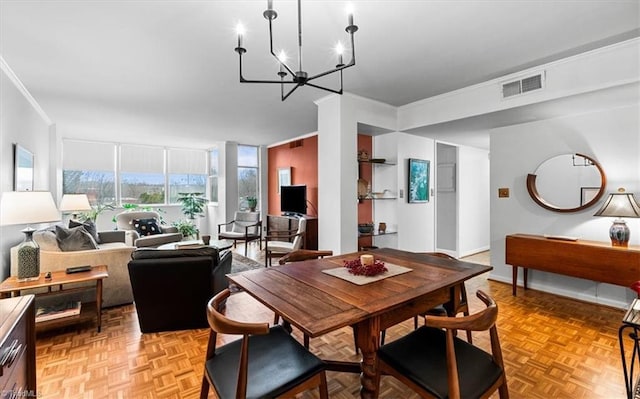 dining area featuring an inviting chandelier, ornamental molding, and light parquet floors