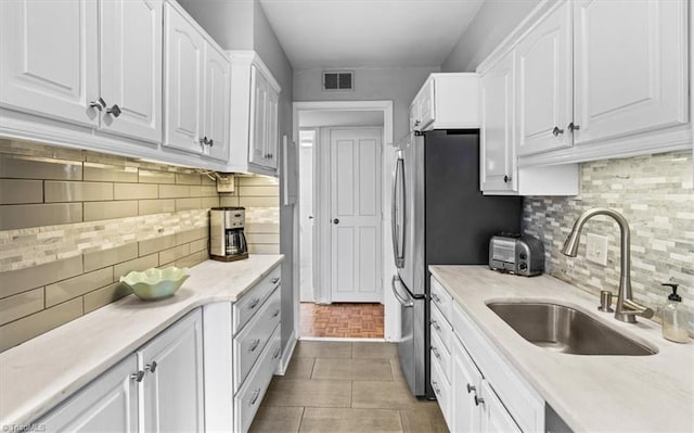 kitchen with sink, decorative backsplash, and white cabinets