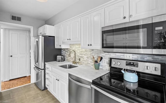 kitchen featuring white cabinetry, appliances with stainless steel finishes, sink, and decorative backsplash