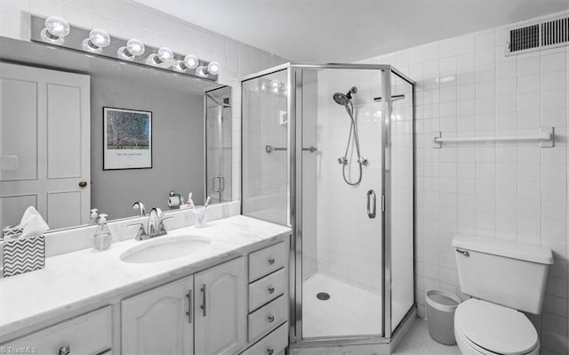 bathroom with vanity, a shower with shower door, and toilet