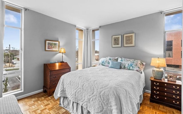 bedroom featuring multiple windows and light parquet flooring