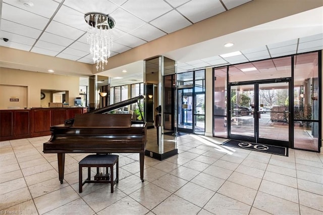 misc room featuring french doors, floor to ceiling windows, and a drop ceiling