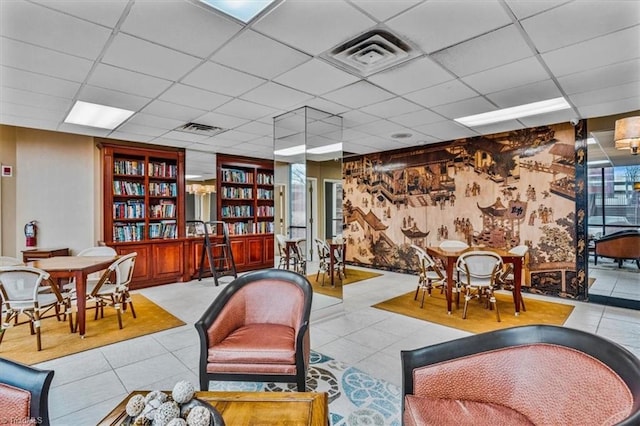 living room featuring light tile patterned flooring and a paneled ceiling