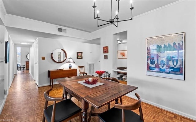 dining room featuring parquet floors, crown molding, and an inviting chandelier