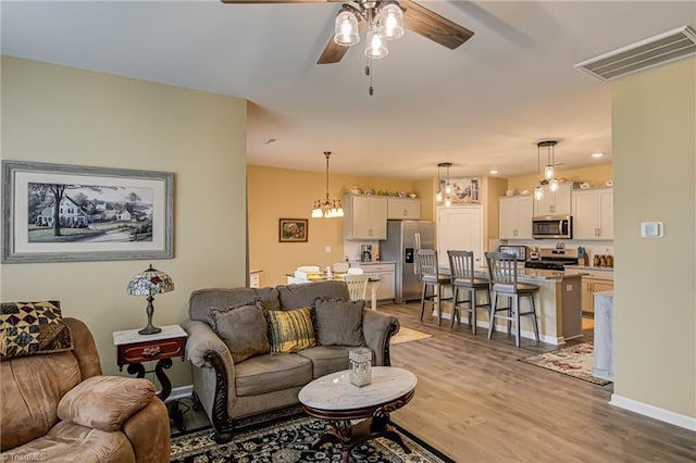 416 Bryson Blvd, Lexington, NC 27295 - living room featuring a ceiling fan, wood finished floors, and a chandelier