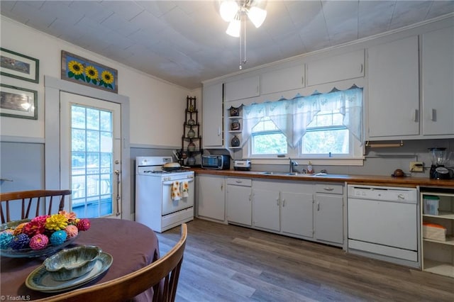 kitchen featuring white cabinetry, ornamental molding, sink, and white appliances