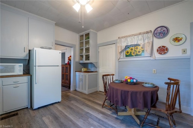 kitchen with white cabinetry, white appliances, ornamental molding, and light hardwood / wood-style floors