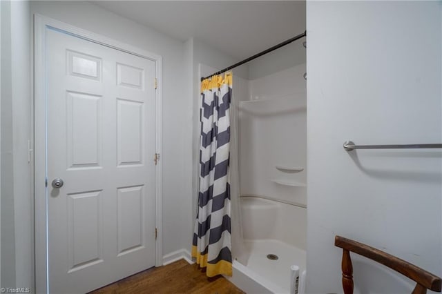 bathroom featuring walk in shower and wood-type flooring