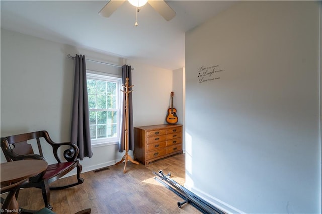 living area with ceiling fan and wood-type flooring