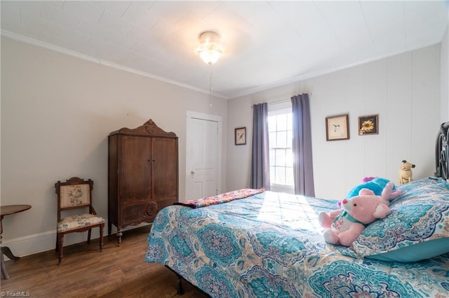 bedroom featuring crown molding and dark wood-type flooring