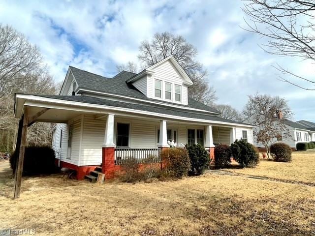 view of front of house with a porch and a front lawn