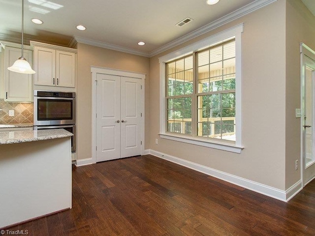 kitchen featuring visible vents, stainless steel double oven, hanging light fixtures, crown molding, and tasteful backsplash