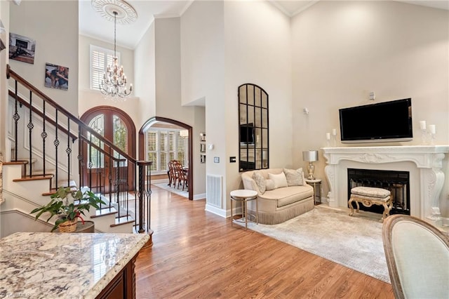 4607 Eden Bridge Dr, Kernersville, NC 27284 - living area with light wood-style floors, a chandelier, crown molding, a high ceiling, and stairway