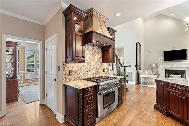 4607 Eden Bridge Dr, Kernersville, NC 27284 - kitchen featuring stainless steel stove, light wood finished floors, backsplash, light stone counters, and ornamental molding