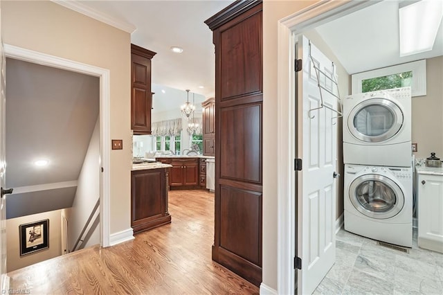 4607 Eden Bridge Dr, Kernersville, NC 27284 - laundry area with stacked washer / dryer, a chandelier, cabinet space, recessed lighting, and light wood-style floors