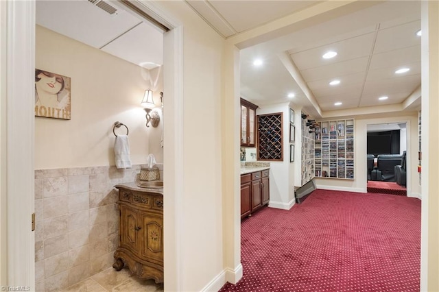 4607 Eden Bridge Dr, Kernersville, NC 27284 - hallway featuring recessed lighting, dark carpet, and tile walls