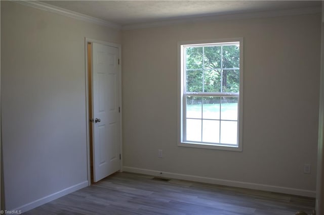 spare room featuring light hardwood / wood-style floors and crown molding