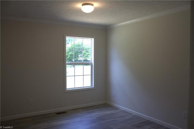 spare room with a textured ceiling, dark hardwood / wood-style floors, and ornamental molding