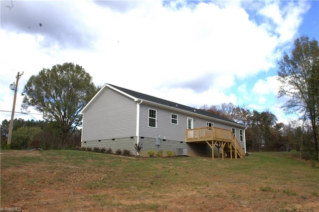 back of property with a wooden deck and a yard