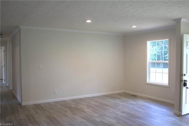 unfurnished room with a textured ceiling, wood-type flooring, and ornamental molding