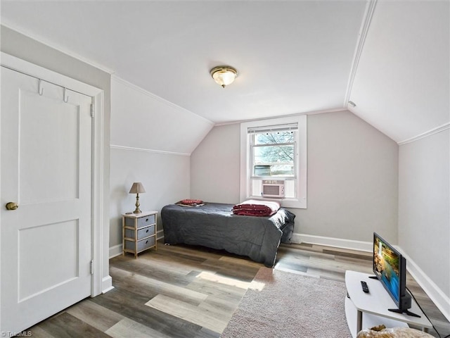 bedroom with baseboards, vaulted ceiling, and wood finished floors