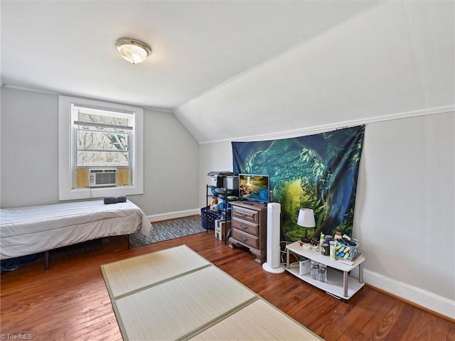 bedroom with vaulted ceiling, cooling unit, wood finished floors, and baseboards