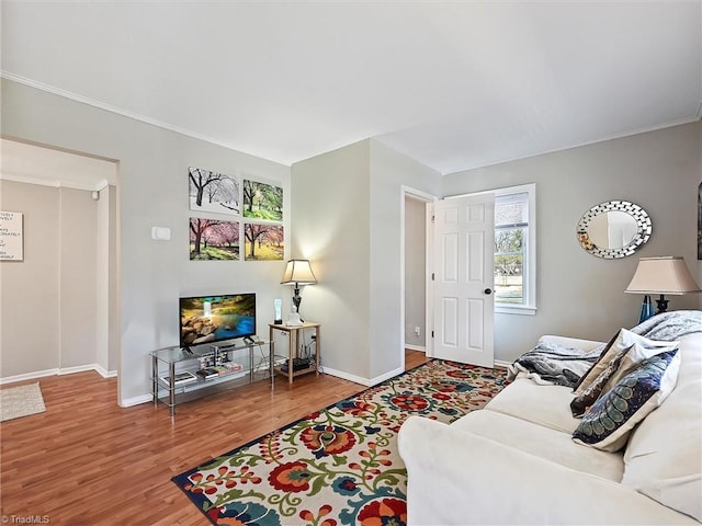 living room featuring crown molding, wood finished floors, and baseboards