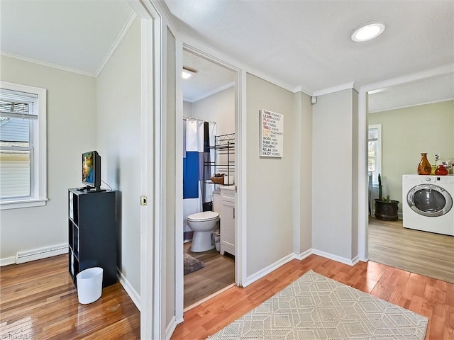 interior space featuring washer / clothes dryer, plenty of natural light, baseboard heating, and laundry area