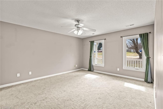 carpeted spare room with ceiling fan and a textured ceiling