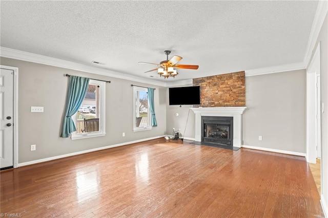 unfurnished living room with ceiling fan, ornamental molding, hardwood / wood-style floors, and a textured ceiling