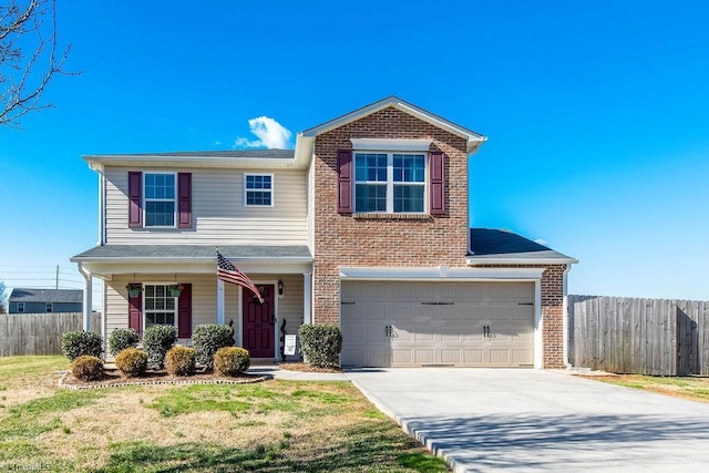 traditional-style home featuring brick siding, a front lawn, fence, concrete driveway, and a garage