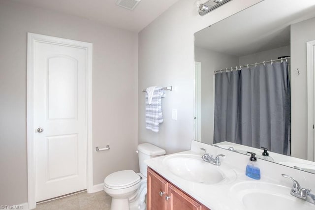 full bathroom with double vanity, toilet, visible vents, and a sink