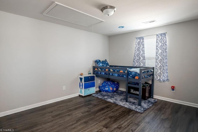 interior space featuring attic access, wood finished floors, visible vents, and baseboards